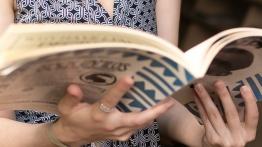 Close up of a comparative literature student holding an open book.