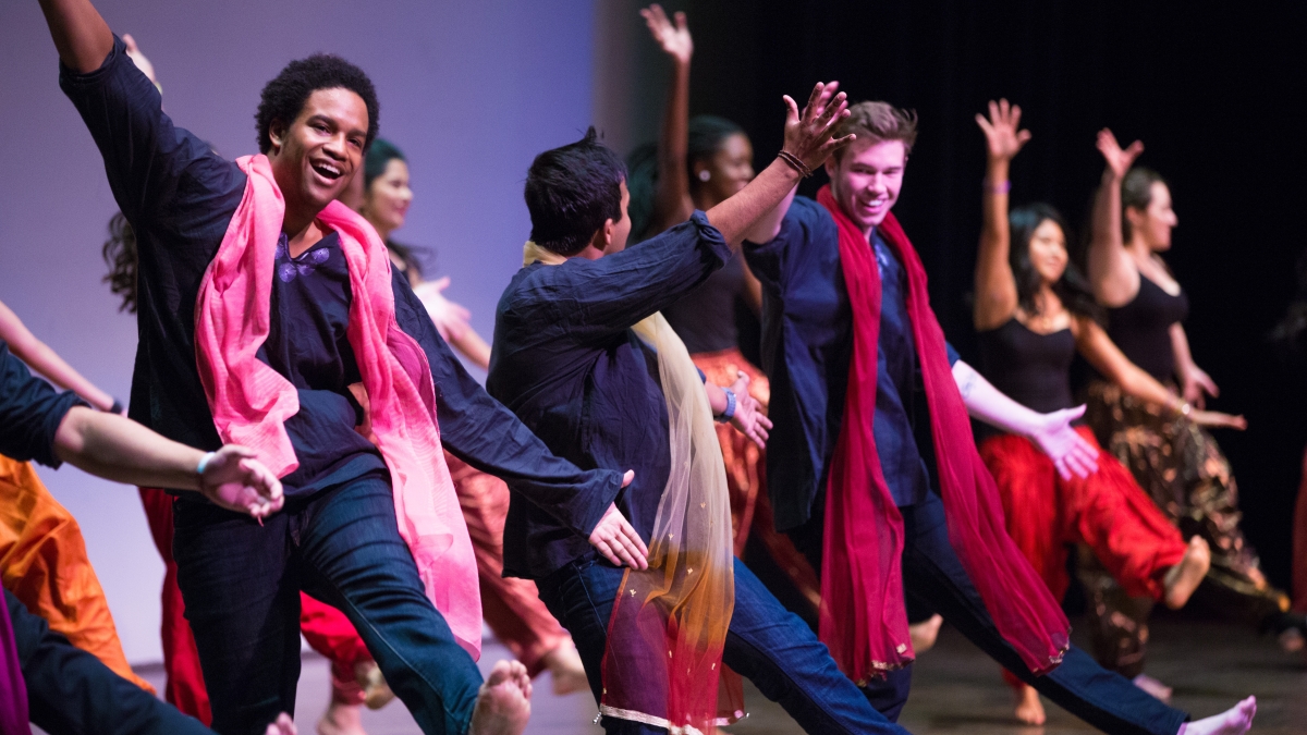 Students participate in Diwali style dance on a stage.