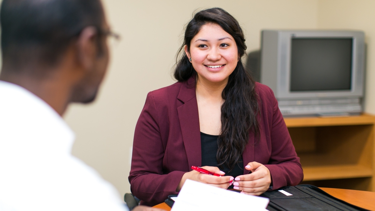 a woman participates in a mock interview in the career services office