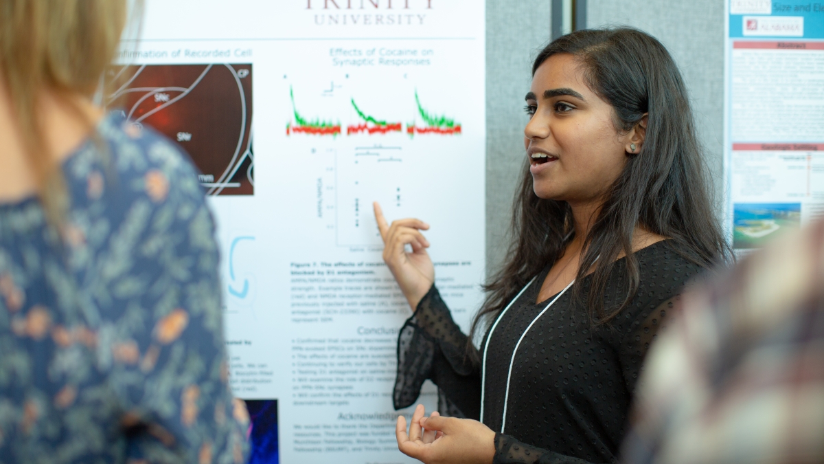 a student presents a poster at the summer undergraduate research symposium