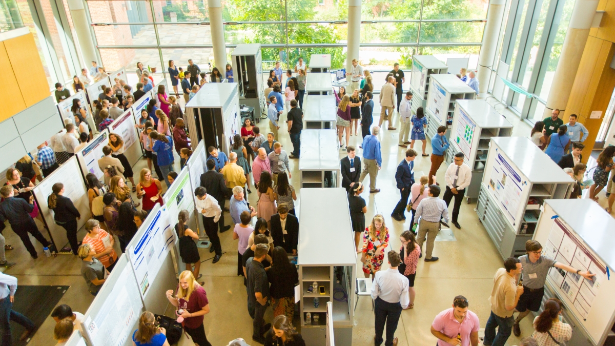 an overhead shot of a large crowd viewing research posters in the CSI cube